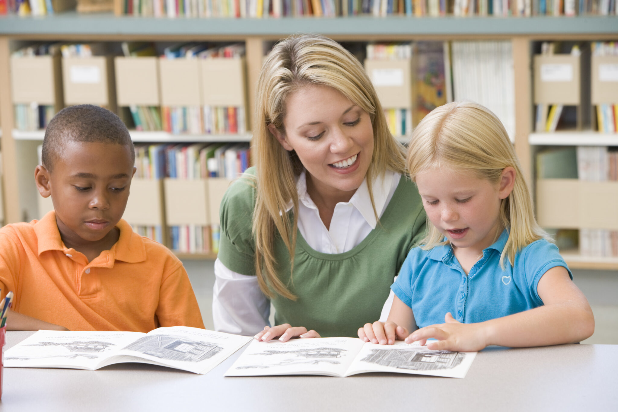 Kindergarten teacher helping students with reading skills